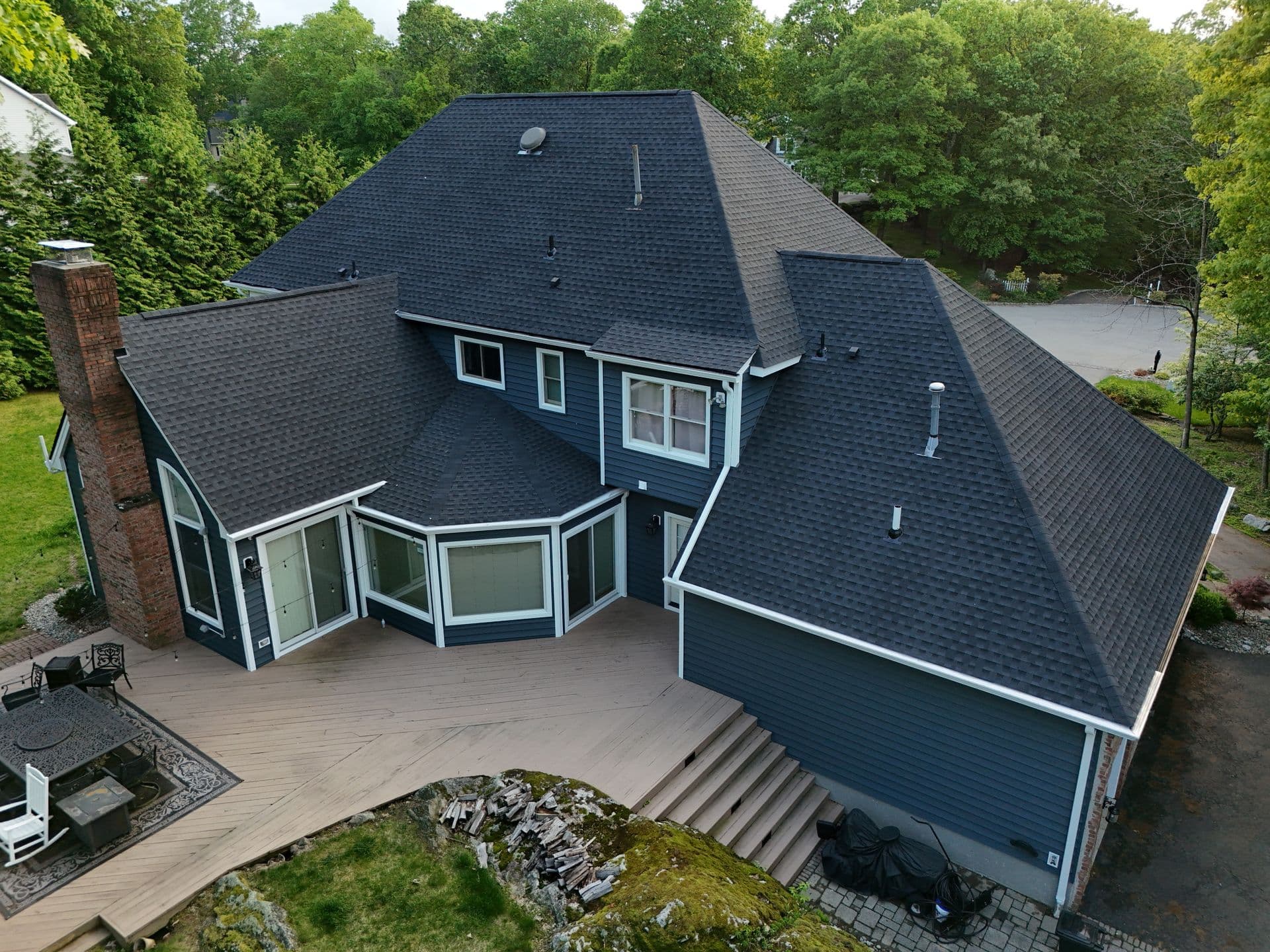 Superior Home Exteriors project — Navy siding · architectural shingle roof · multi-pitch detail