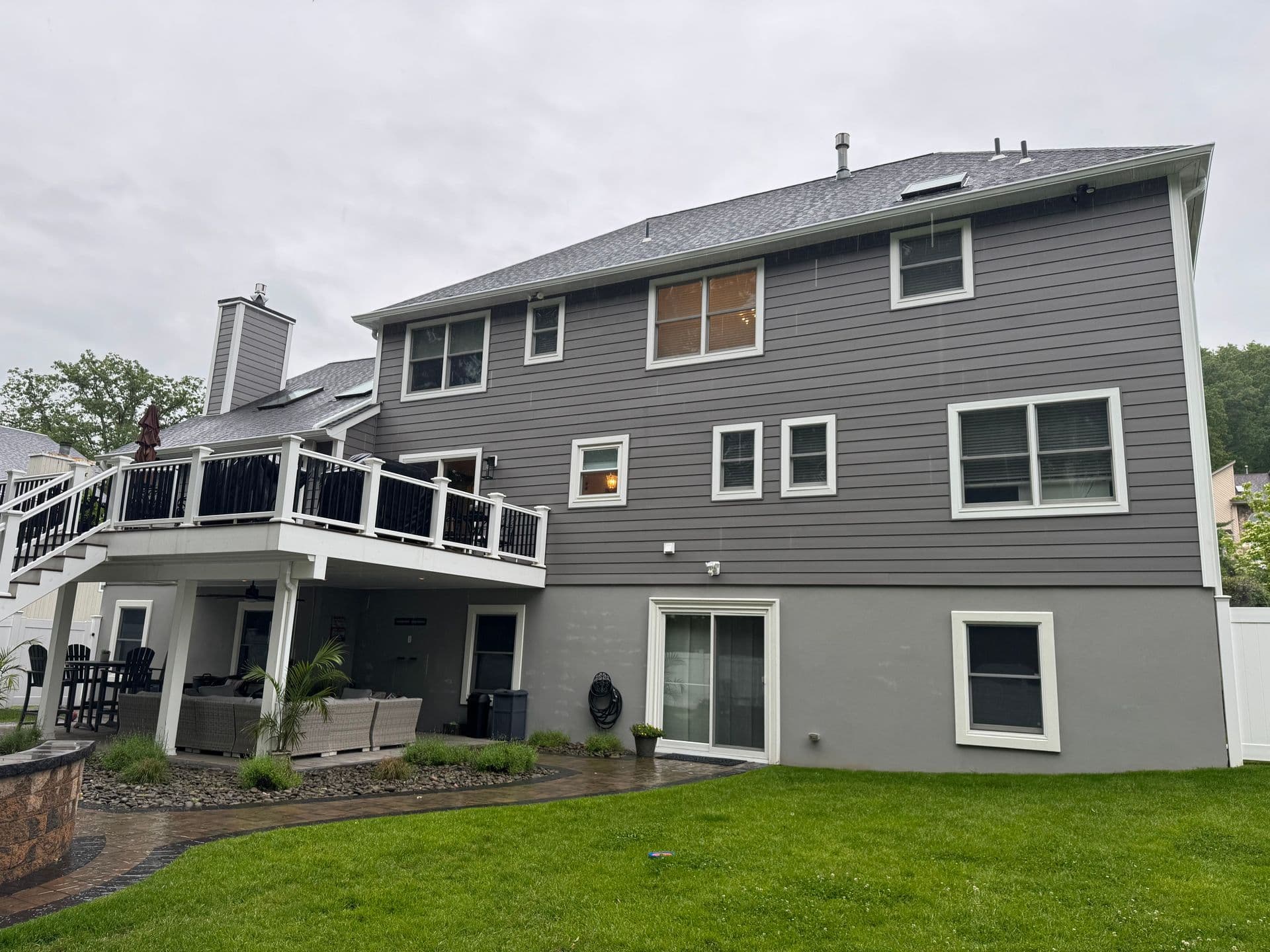 Superior Home Exteriors project — Gray siding · rear deck · two-story exterior