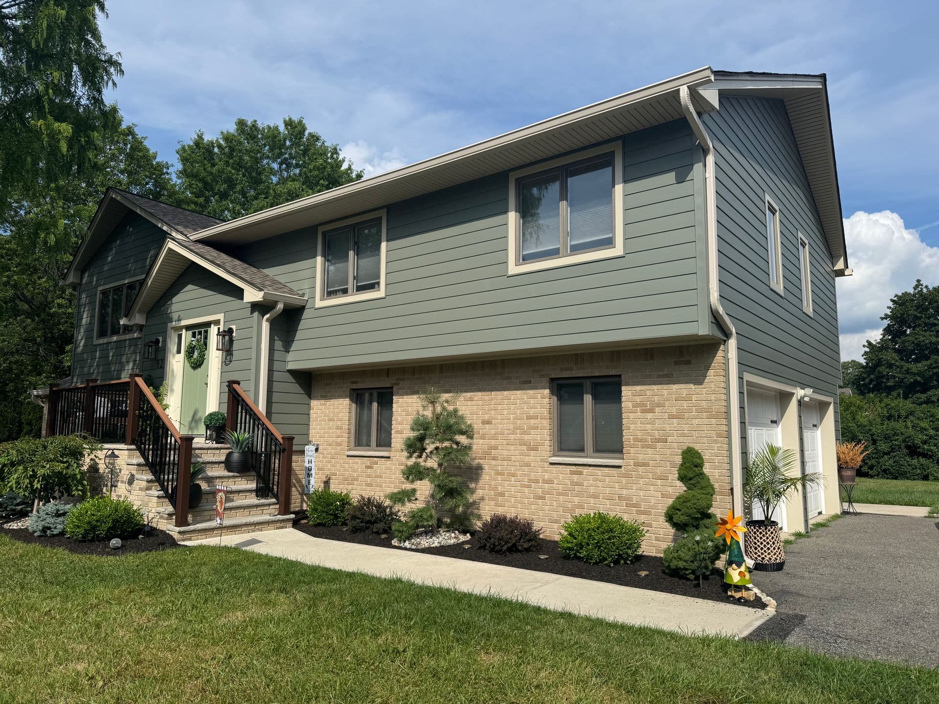 Superior Home Exteriors project — Sage siding · stone foundation accent · covered porch