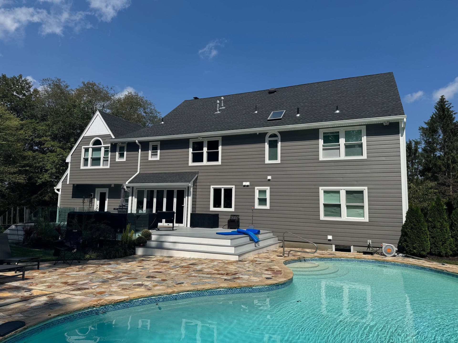 Superior Home Exteriors project — Gray siding rear · pool surround · flagstone patio